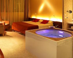 Suite con bañera de hidromasaje privada junto a la cama en Hotel Diagonal Zero Barcelona